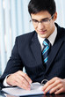 Photo: Portrait of writing businessman working at office Portrait of writing businessman working at office