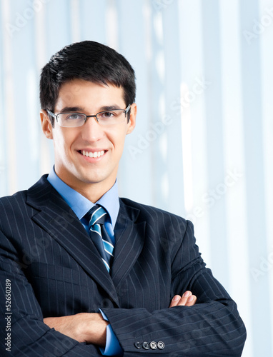 Photo: Happy smiling businessman at office Happy smiling businessman at office