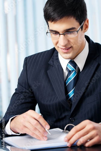 Photo: Portrait of writing businessman working at office Portrait of writing businessman working at office