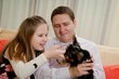 Child with father playing with dog