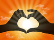 heart made with fingers on sunset background