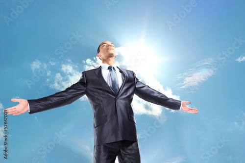 Photo: Happy businessman standing outside with arms outstretched Happy businessman standing outside with arms outstretched