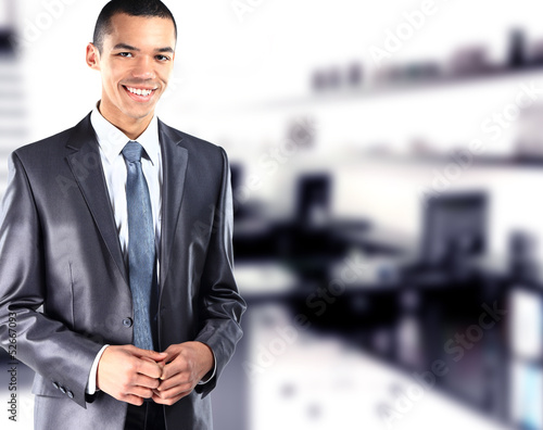 Photo: African American businessman with office in background African American businessman with office in background