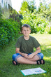 Photo: boy with a book on the grass boy with a book on the grass