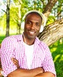 Young happy smiling african american listens to music in a park