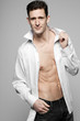 Photo: Handsome man in white shirt on gray. Handsome man in white shirt on gray.
