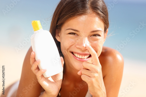 Photo: Suntan lotion woman applying sunscreen solar cream Suntan lotion woman applying sunscreen solar cream