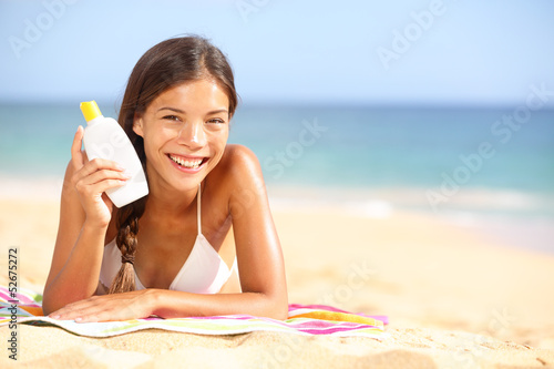 Photo: Sunscreen woman showing suntan lotion bottle Sunscreen woman showing suntan lotion bottle