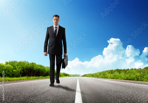 Photo: business man walking on the road business man walking on the road