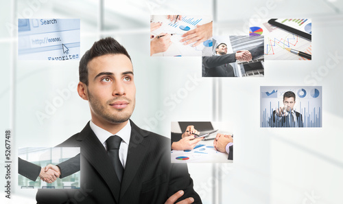 Photo: Businessman looking to business related images Businessman looking to business related images