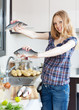 Smiling blonde woman with seabass fish