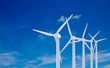 White wind turbine generating electricity on blue sky