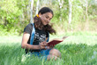 Teen girl reading a book on nature