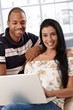 Happy couple with laptop computer smiling