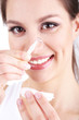 Young woman putting contact lens in her eye close up