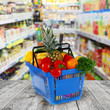 Shopping basket with groceries  on shop of background