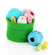 Colorful yarn for knitting in green basket isolated on white