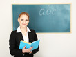 Portrait of teacher woman near chalkboard in classroom