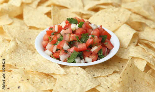Photo: A bowl of pico de gallo surrounded by tortilla chips A bowl of pico de gallo surrounded by tortilla chips