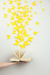 Paper yellow butterflies fly out of book