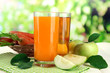 Glasses of juice, apples and carrots