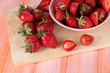 Foto: Strawberries in bowl on cutting board on wooden table Strawberries in bowl on cutting board on wooden table