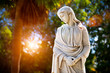 A young woman with folded hands looking down. Sculpture