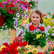 Lovely girl holding flowers in garden center.