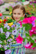 Lovely girl holding flowers in garden center.