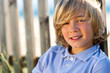Face shot of handsome boy next to fence.
