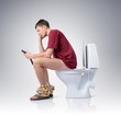 Photo: Man with mobile phone sitting on the toilet Man with mobile phone sitting on the toilet