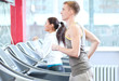 Woman and man at the gym exercising
