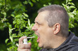 Man blows medicine in mouth