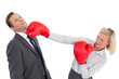 Businesswoman hitting colleague with her boxing gloves