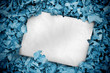 White poster buried into blue leaves