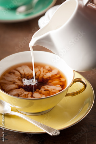 Photo: Pouring milk on a tea cup Pouring milk on a tea cup