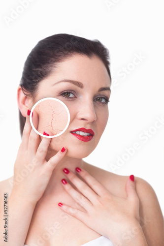 Photo: Attractive woman rubbing her skin with close up of her wrinkles Attractive woman rubbing her skin with close up of her wrinkles