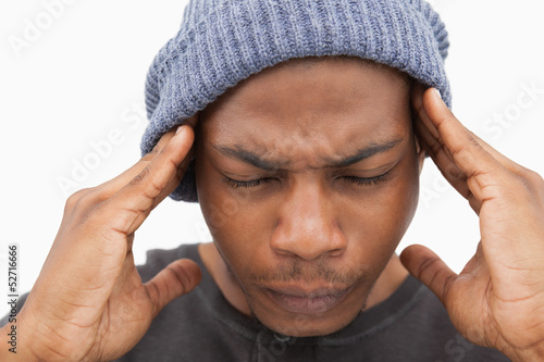 Photo: Man in beanie hat grimacing with pain of headache Man in beanie hat grimacing with pain of headache