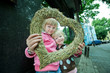 Two girls look through decorated heart into the camera