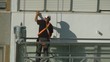 Construction worker on scaffolding repairing the building