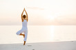Caucasian woman practicing yoga at seashore Caucasian woman practicing yoga at seashore