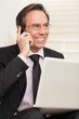 Happy business man speaking on cellphone while at stairs