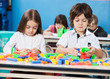 Children Playing With Construction Blocks In Classroom