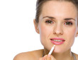 Photo: Beauty portrait of young woman applying white eye liner Beauty portrait of young woman applying white eye liner