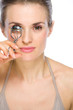 Beauty portrait of young woman using eyelash curler