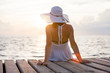 Caucasian woman takes rest at wooden pier to Indian ocean