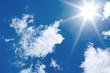 blue sky with sun and cumulus clouds