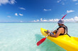 Young caucasian man kayaking in sea at Maldives