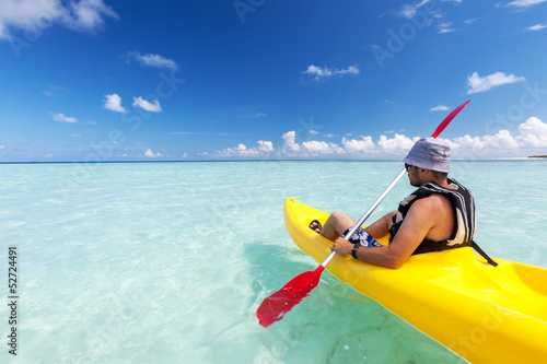 Photo: Young caucasian man kayaking in sea at Maldives Young caucasian man kayaking in sea at Maldives