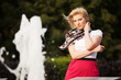canvas print picture - Happy young woman against a city fountain